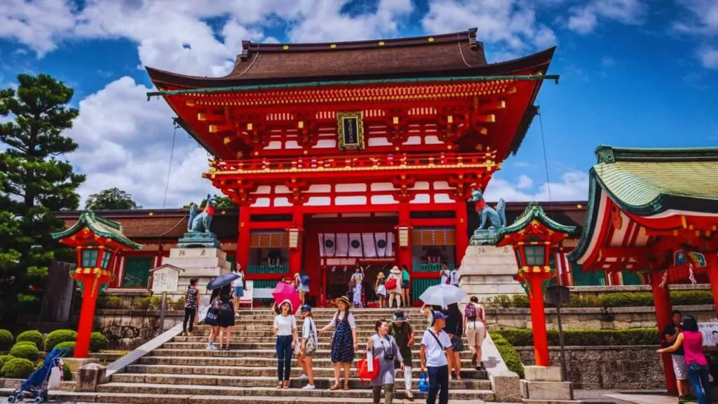 Tourists on steps at entrance to Fushimi Inari Shrine