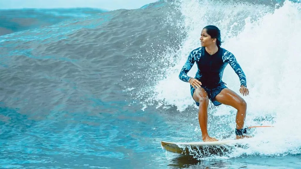 Surfer riding a wave in the ocean, showcasing strength and focus.