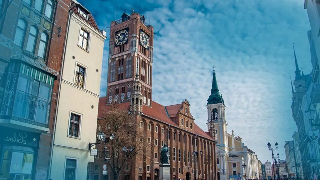 Scenic view of a historic European town square featuring a tall clock tower